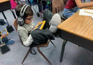 child with headphones using a tablet