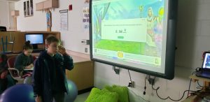 student presenting at an interactive whiteboard