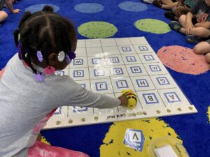 elementary student playing with a robot